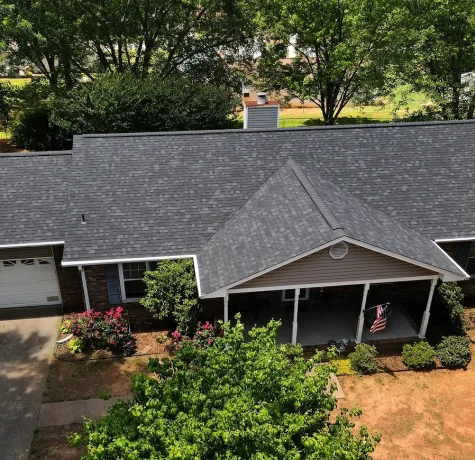 Ranch home with new gray shingle roof featuring front gable over porch